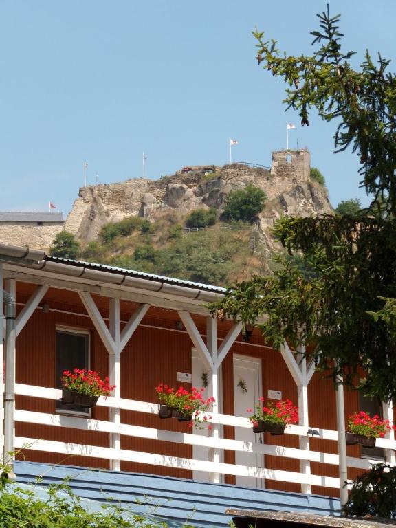 a house with flowers on the balcony with a hill in the background at Gyarmati Vendégház Sirok in Sirok