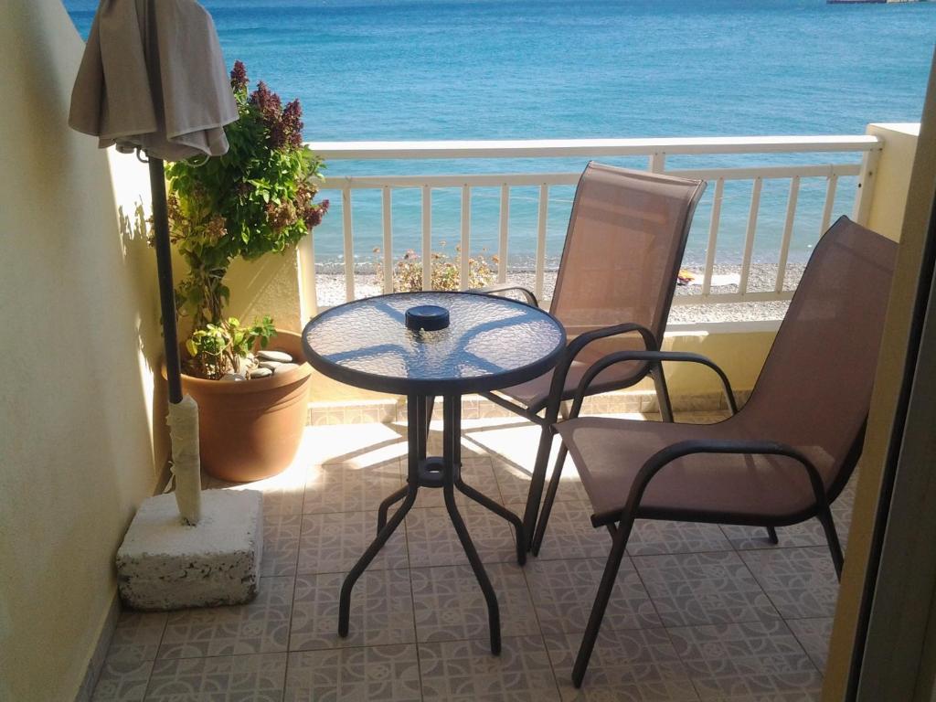 un tavolo e due sedie su un balcone con vista sull'oceano di Thalassa View Apartments a Diafani
