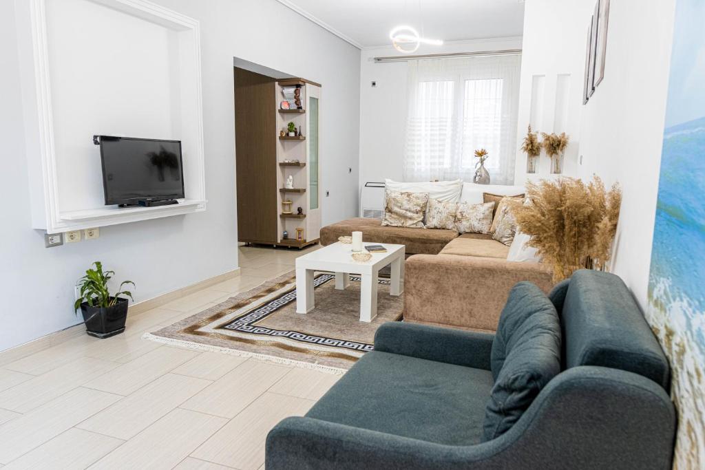 a living room with a couch and a tv at Vila Goxhaj in Sarandë