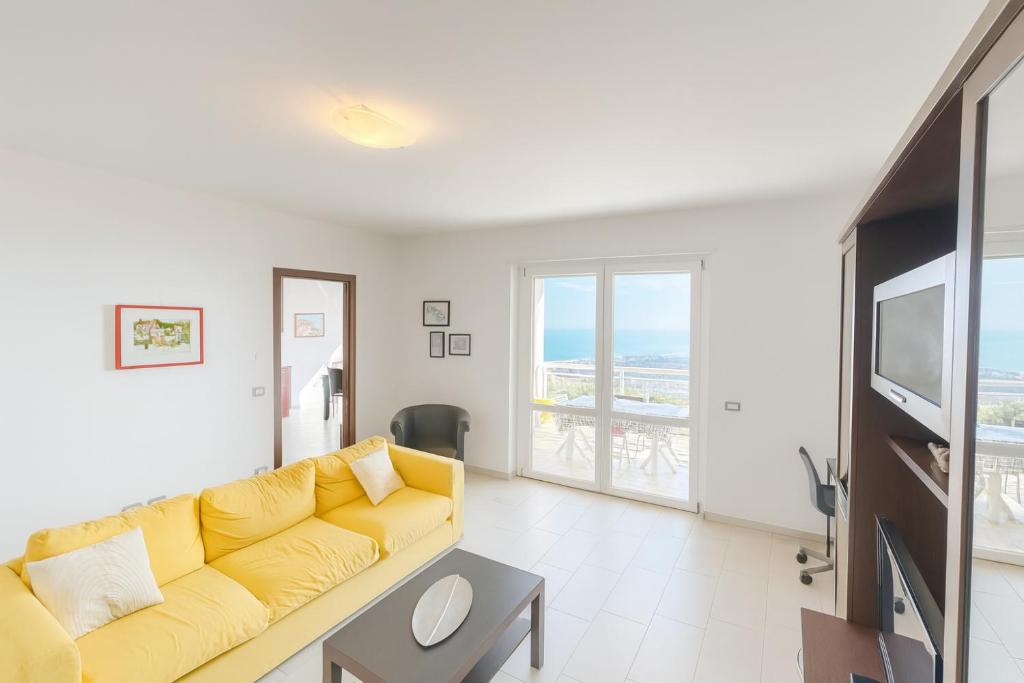 a living room with a yellow couch and a television at DreamLiving Vasto Panorama in Vasto