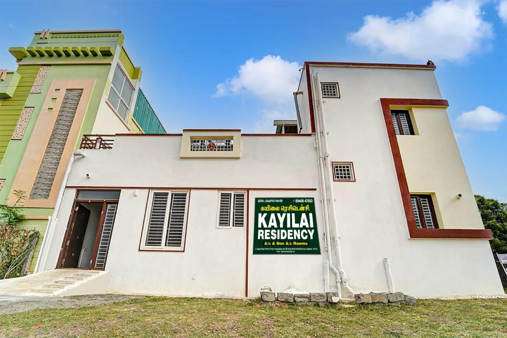 a building with a sign on the side of it at Kayilai Residency in Pīlamedu
