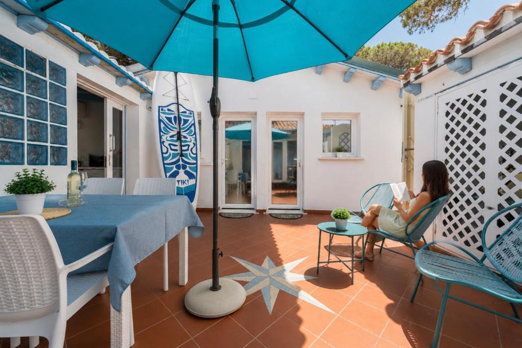 a woman sitting in a chair under an umbrella on a patio at Sweet home Santa Lucia in Santa Lucia