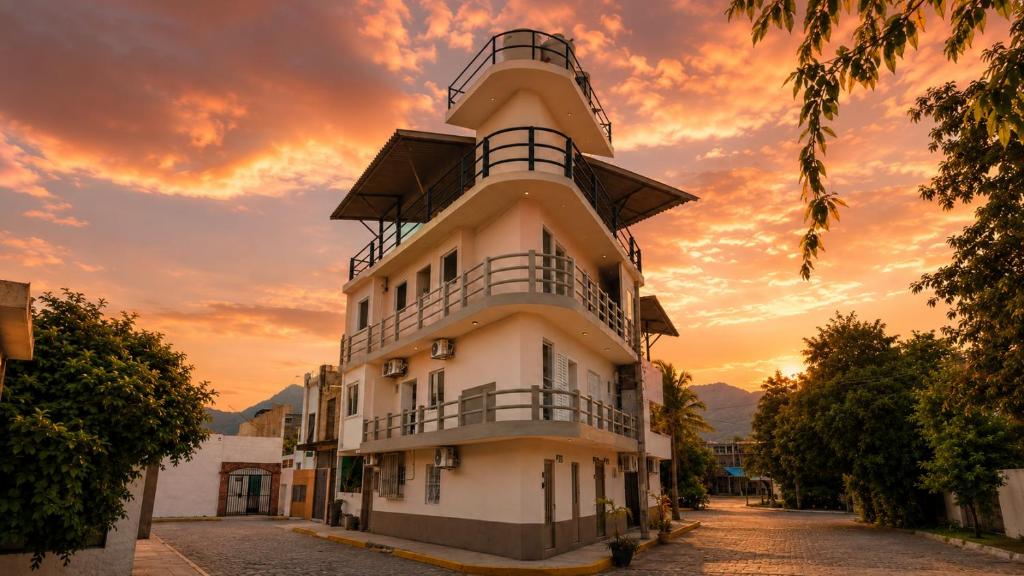 a building with a sunset in the background at Polly's Home Boutique GuestHouse & Private Suites in Aralias in Puerto Vallarta