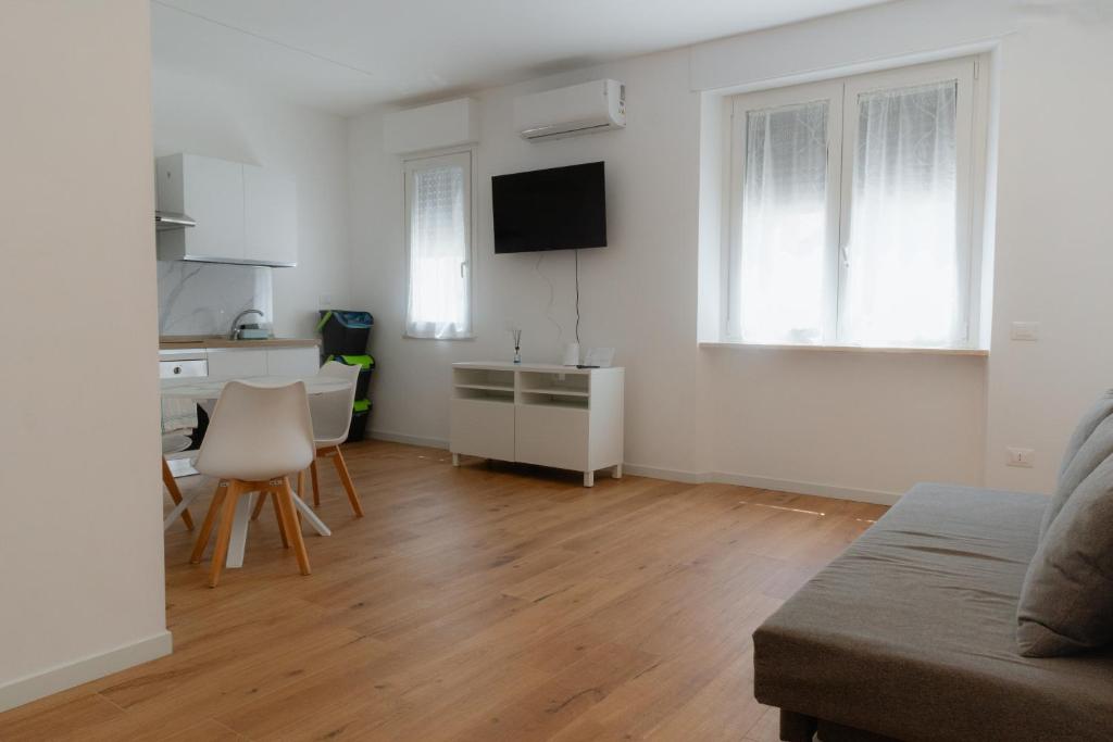 a white living room with a kitchen and a table at Mara's home in San Salvo