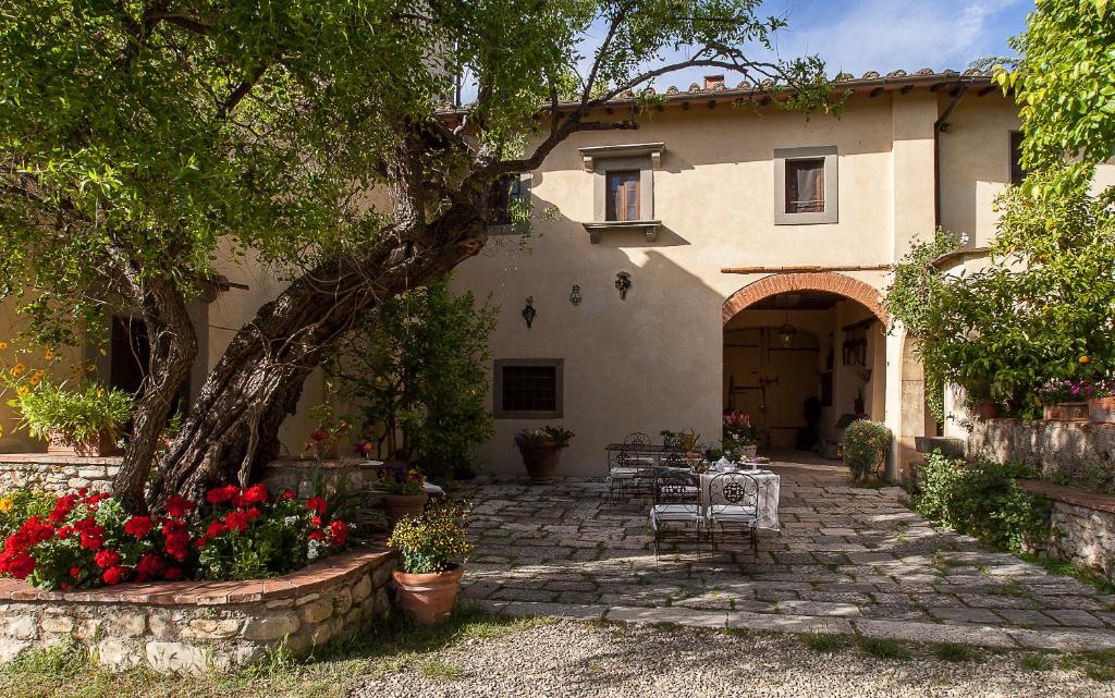 a house with a patio and flowers in front of it at Villa Il Paradisino in Sesto Fiorentino