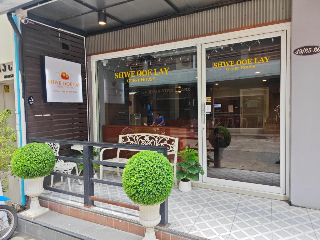 a shop front with two benches in front of a store at Shwe Ooe Lay Guest House 2 in Pratunam