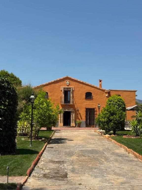 a large brick building with a driveway at The Pines Hotel in Culla