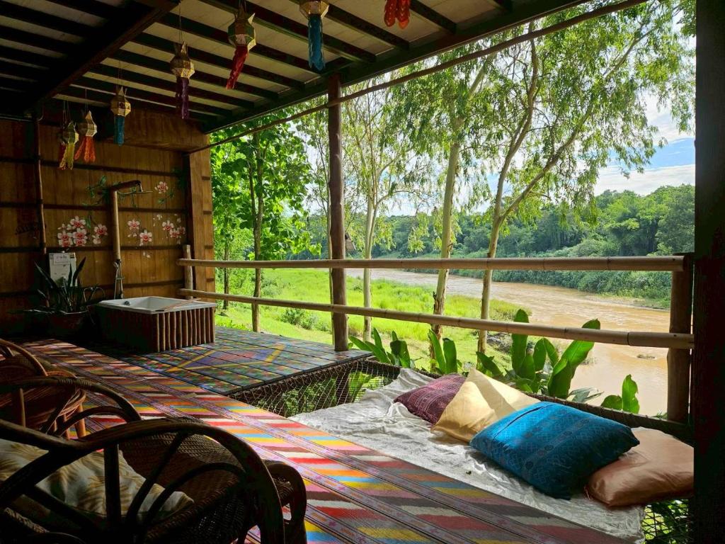 a screened in porch with a view of a field at Nan De Panna Homestay in Nan