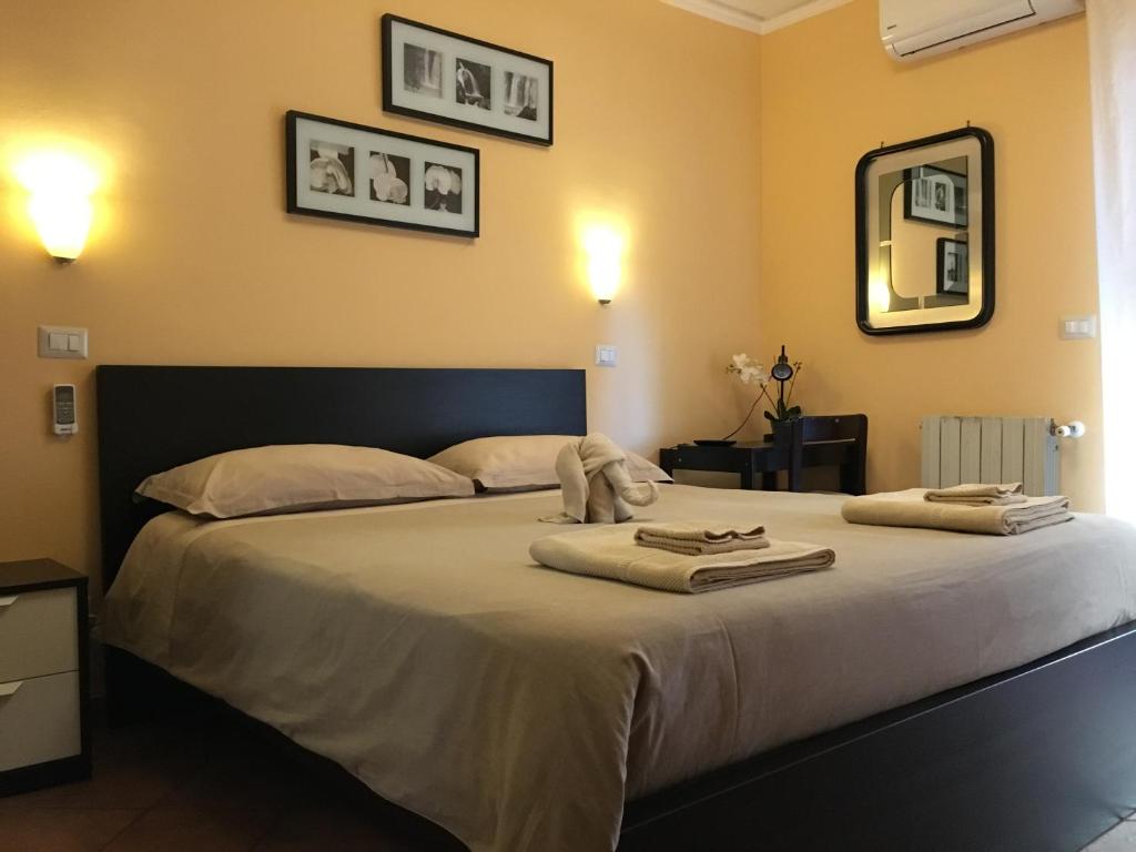 a bedroom with a large bed with towels on it at Tano's in Giardini Naxos
