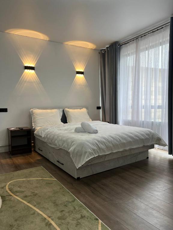 a bedroom with a large bed with two lights on it at Bon Hostel Kg in Bishkek