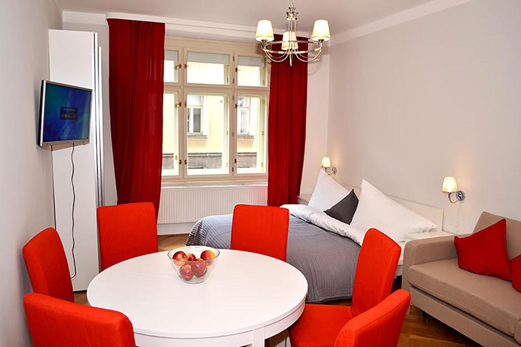 a small room with a bed and a table and red chairs at Classic 2BDR suite by Ruterra in Prague