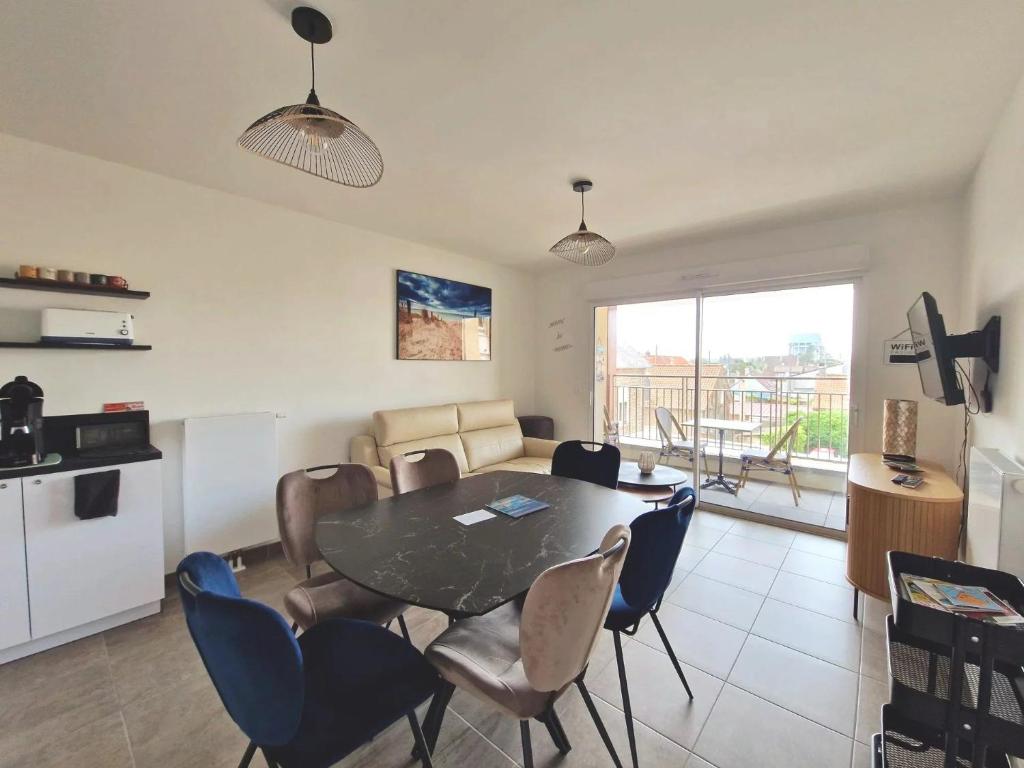 a kitchen and dining room with a table and chairs at La Perle bleue in Berck-sur-Mer