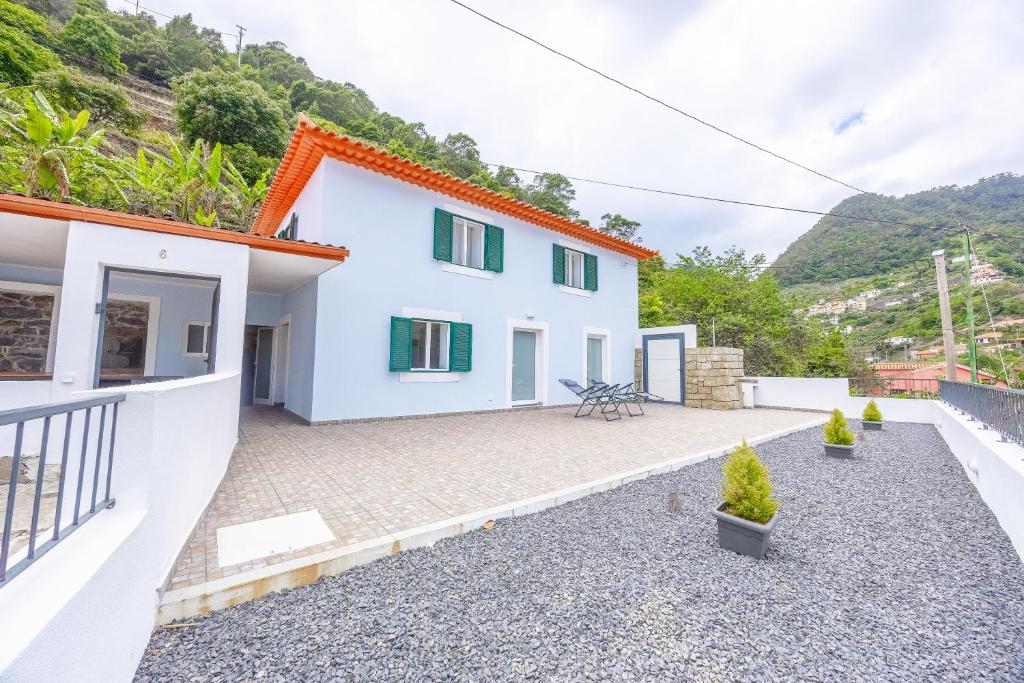 a white house with a courtyard with potted plants at Casa da Floresta in Machico