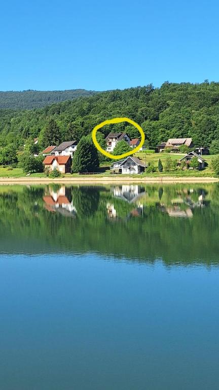 a house with a yellow circle on top of a lake at Lake Crown in Ogulin