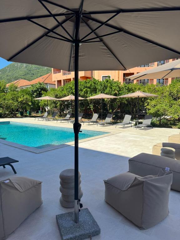 a large umbrella sitting next to a swimming pool at Guesthouse Orlović in Budva