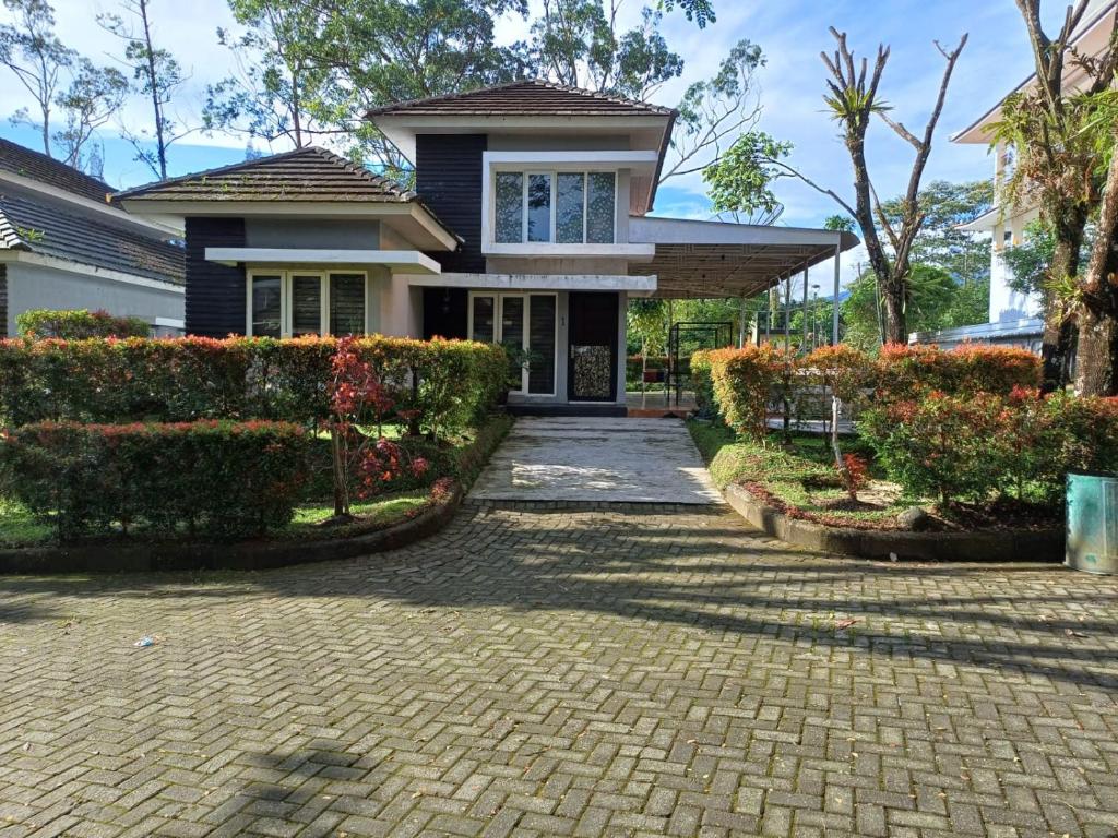 a house with a brick driveway in front of it at Villa GreenHill A1 SibolangitView in Bandarbaru
