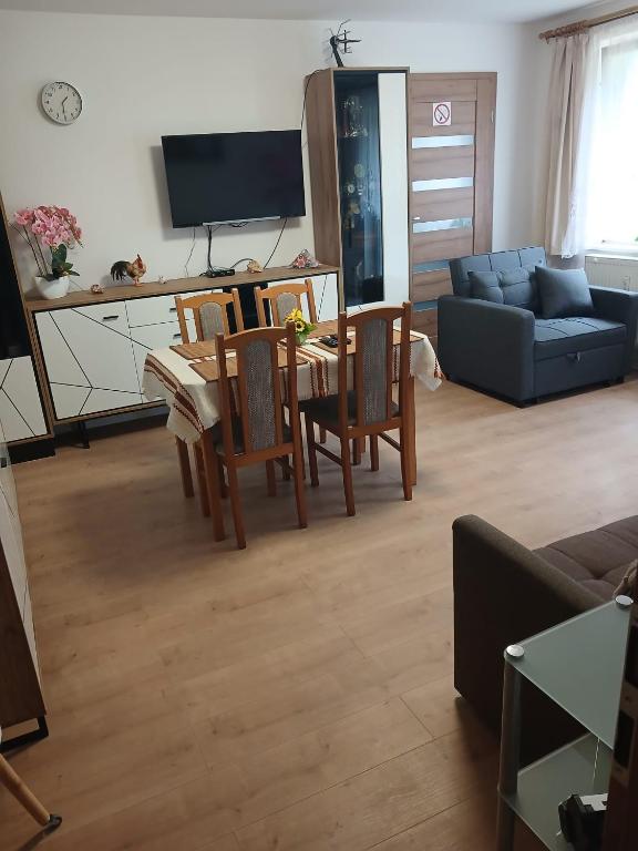 a living room with a table and chairs and a couch at TANIE NOCLEGI u WOJTKA in Cieplice Slaskie Zdroj
