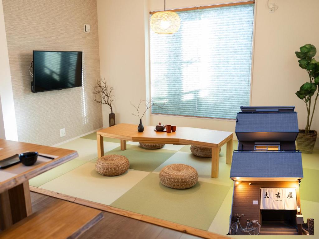 a living room with a table and a bench and a tv at 大吉屋3号館 名駅そばの一棟貸し in Nagoya
