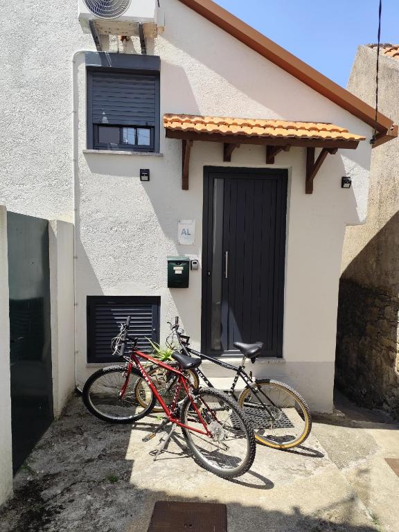 two bikes parked in front of a house at CASA do AÇÔR in Aldeia das Dez