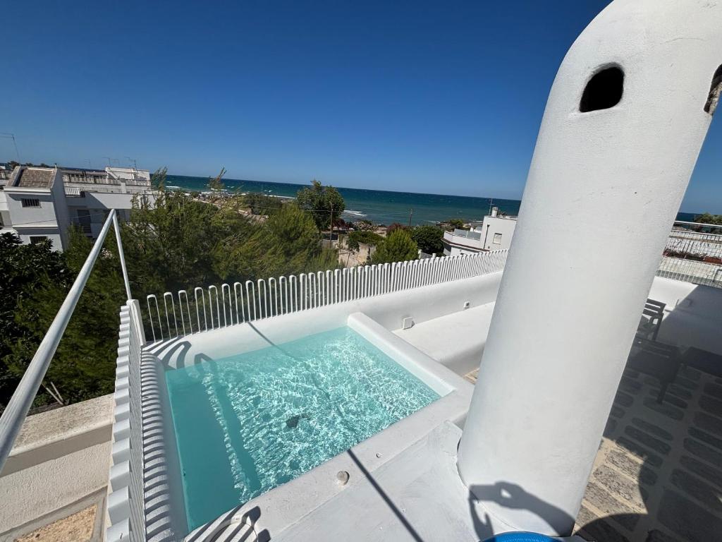 a swimming pool on the roof of a house with a surfboard at Casa Mediterranea al mare, Jacuzzi, Torre Guaceto, Ostuni in Specchiolla