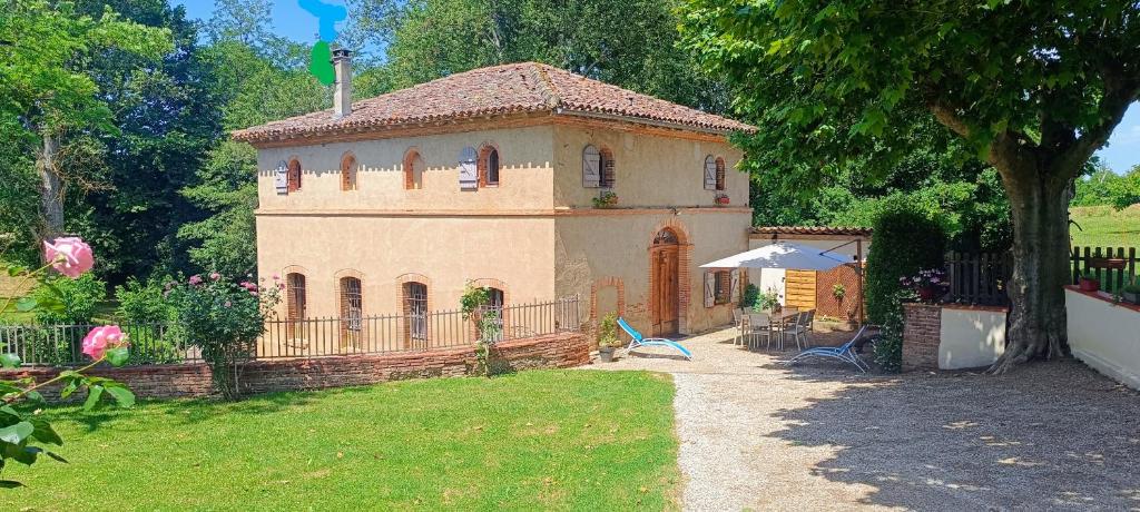 a small house with a fence in a yard at Le moulin de Christine in Saint-Nauphary