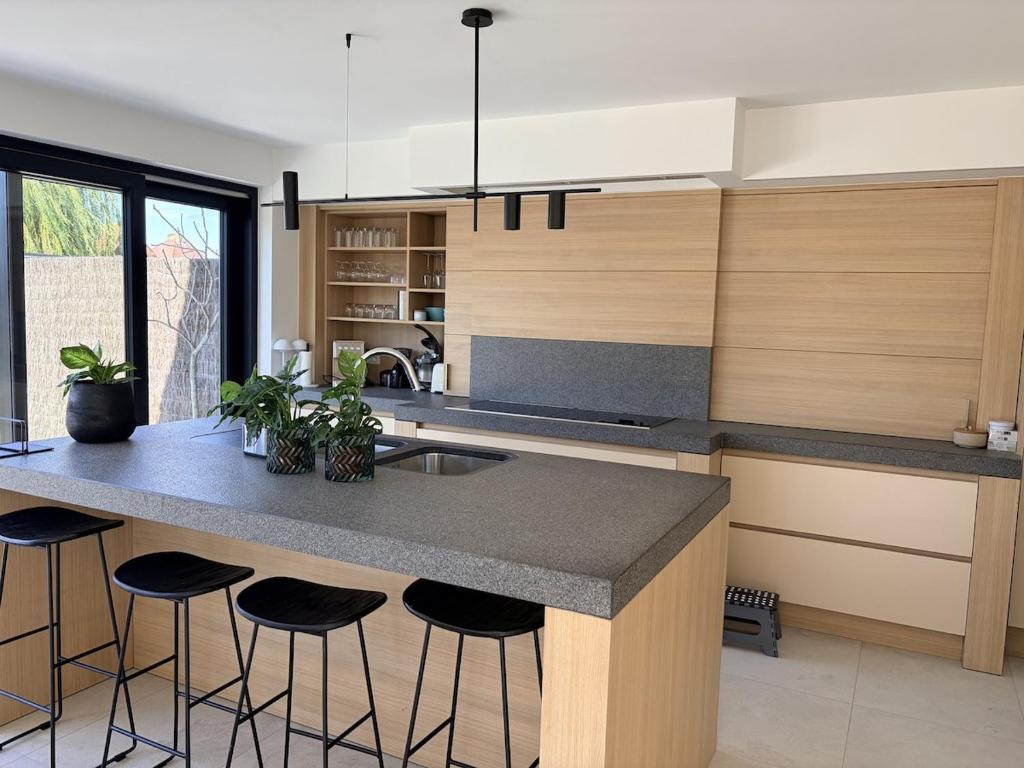 a kitchen with a island with bar stools at Ten Zilte in Blankenberge