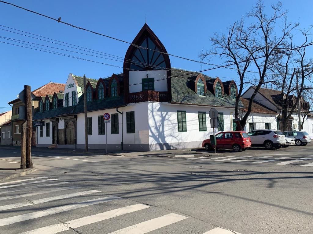 a building on a street with cars parked in front of it at Góbé Csárda in Oradea