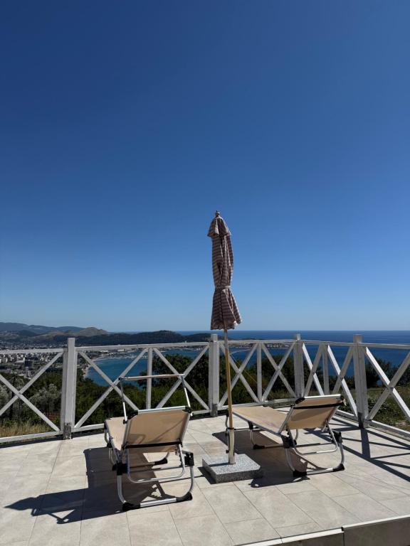 a pair of chairs sitting on a balcony with a lighthouse at Panorama View Holiday Home in Šušanj