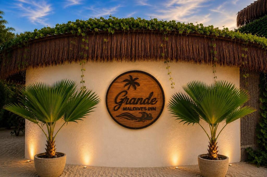 a sign on the side of a building with two palm trees at Grande Maldives Inn in Himmafushi