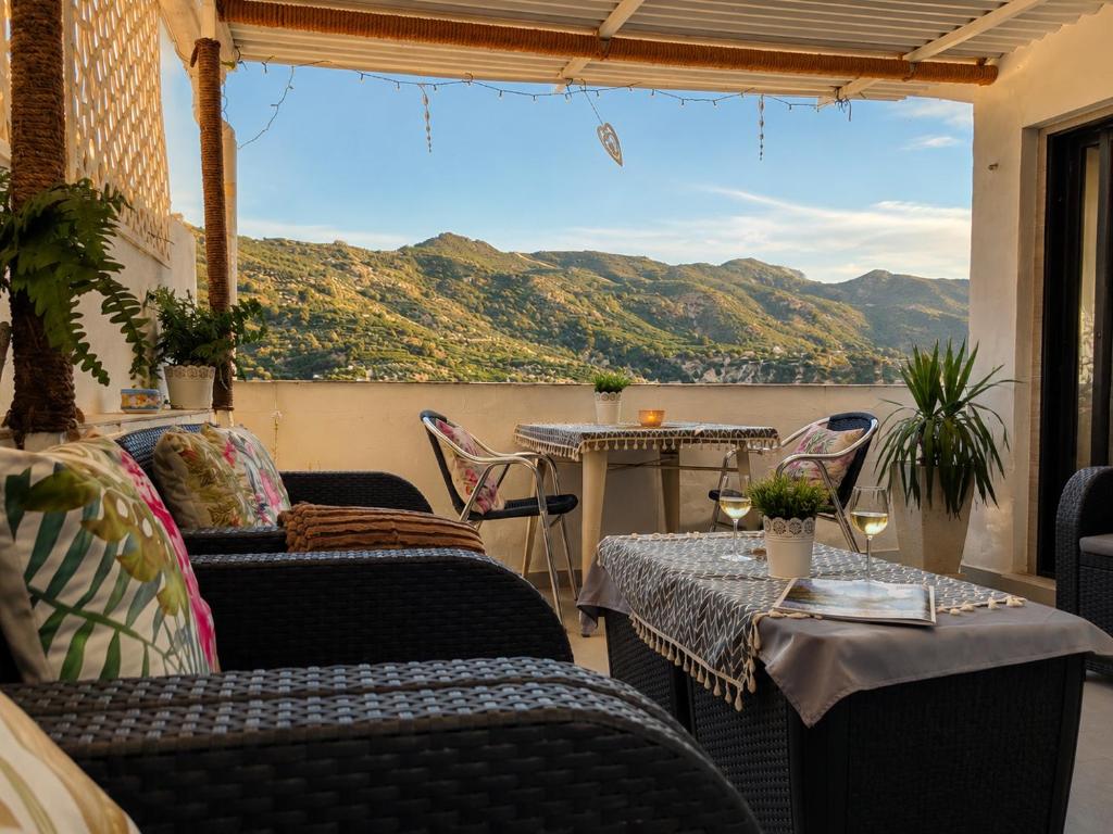 a balcony with couches and a table with a view at Villa Otivar - Rio Verde in Otívar