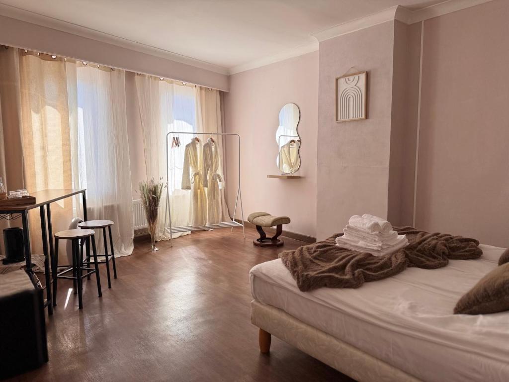 a bedroom with a bed and a table and chairs at Maison Rosé in Hasselt