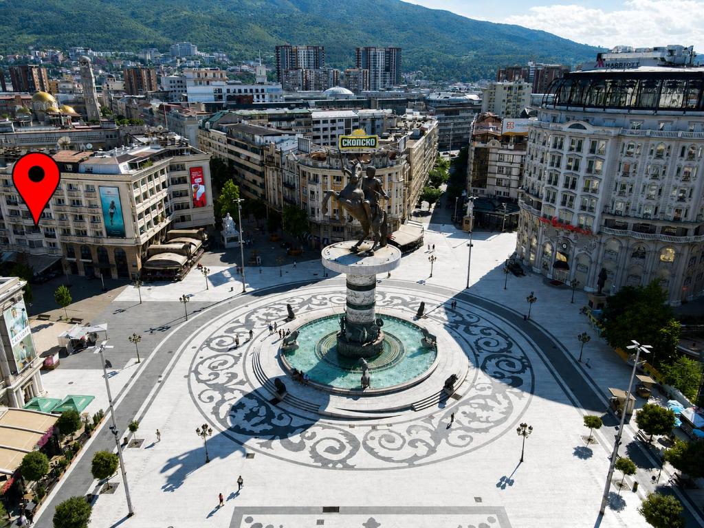 a city with a fountain in the middle of a city at FORUM Square in Skopje