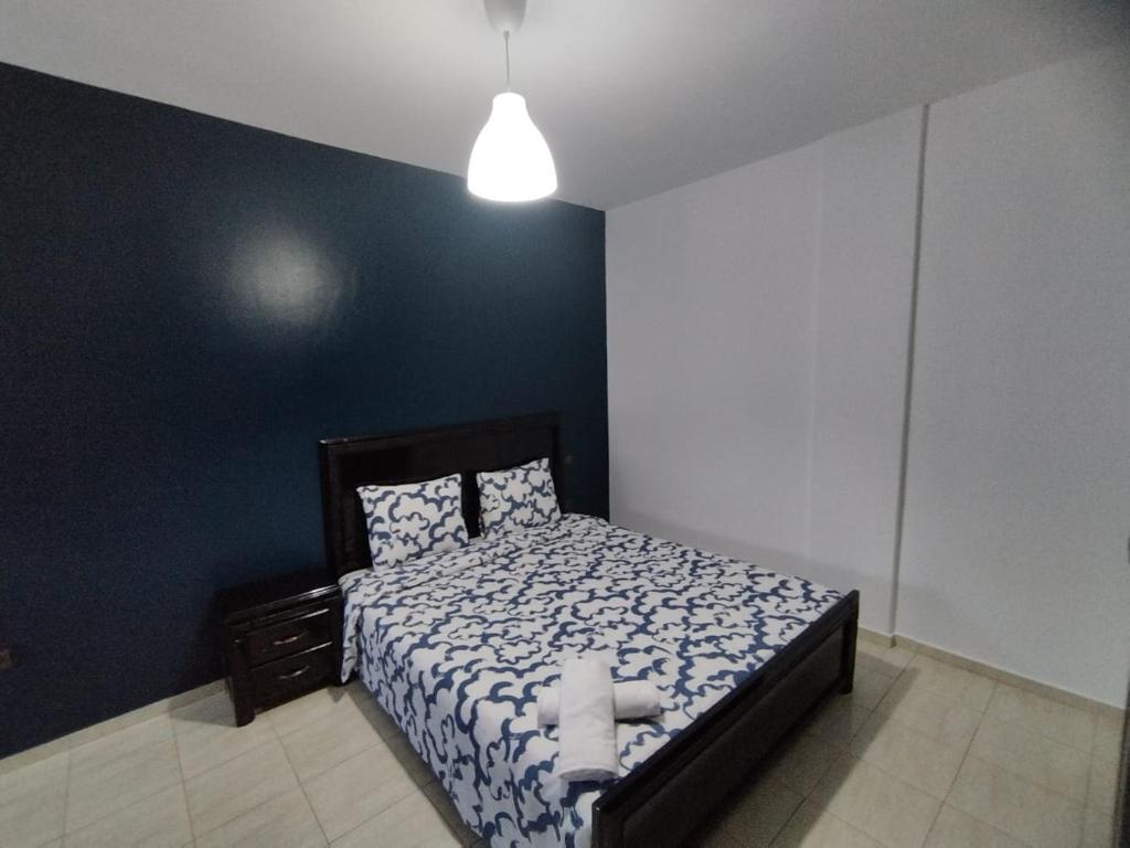 a bedroom with a bed with a blue wall at heartofrabat in Rabat