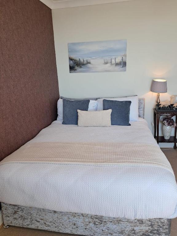 a bedroom with a large bed with blue pillows at Glenlara House in Youghal