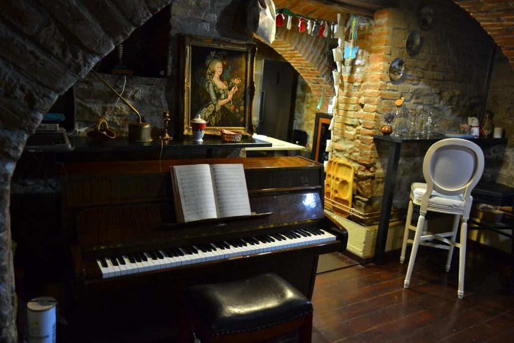 a piano sitting in a room with a chair at Casa Huber in Cîrţa