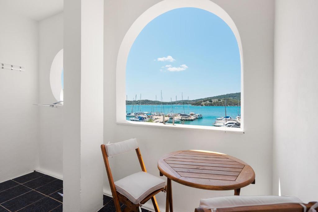 a table and chairs in a room with a window at Irene Bed & Breakfast Tisno in Tisno