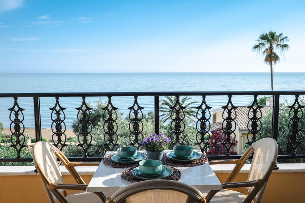 a table with chairs and a view of the ocean at Corfu Dream Holidays Villas in Glyfada