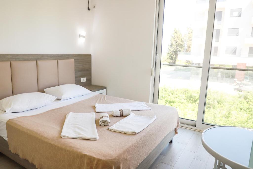 a bedroom with a bed with towels and a table at Rasi Luxury Apartments in Ulcinj