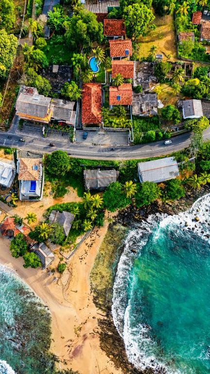 an aerial view of a beach with houses and the ocean at New Moonstone Tangalle in Tangalle