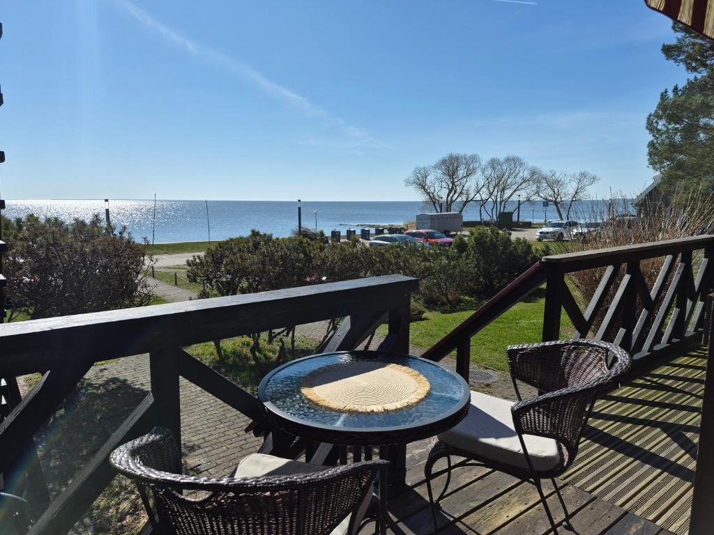 a table and chairs on a balcony with the beach at Curonian Coast studio in Nida