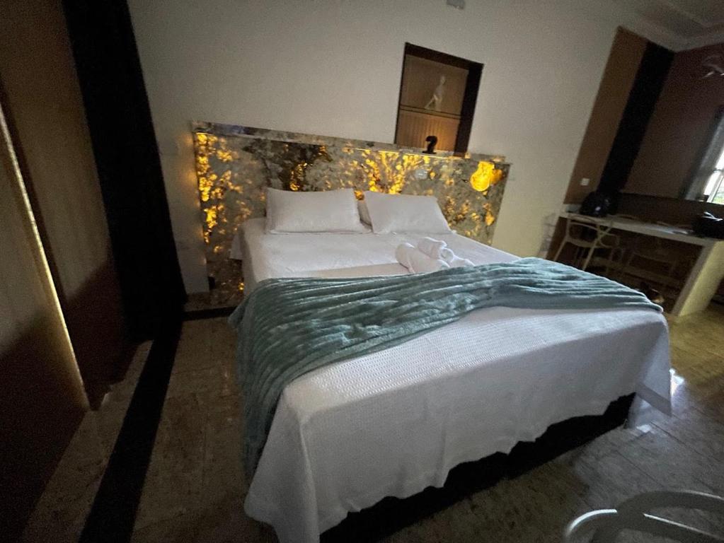 a bedroom with a large white bed with a headboard at Studio aconchegante - Próx Thermas - Carrara de Carrara in Andradina