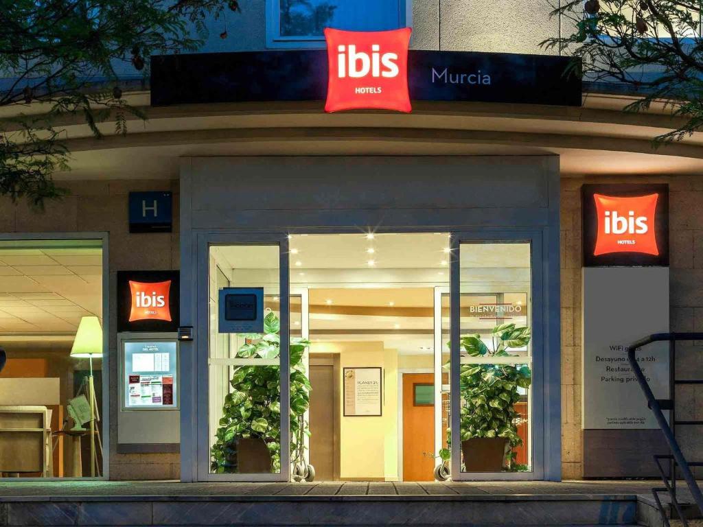 a ups store with two red signs in front of it at Ibis Murcia in Murcia