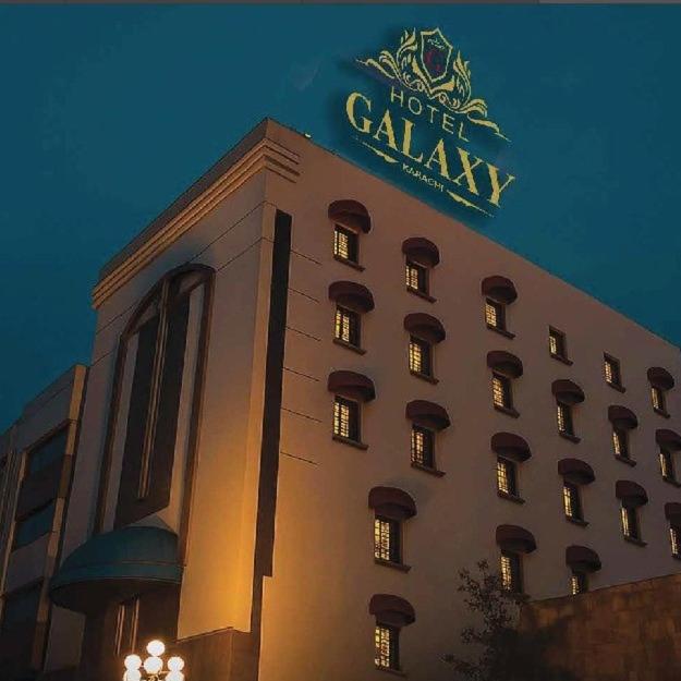 a hotel building with a sign on top of it at Hotel Galaxy in Karachi