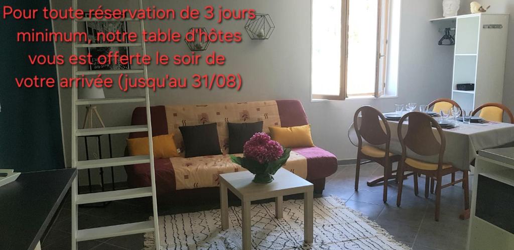 a living room with a couch and a table at L'Hermitage - piscine et mini golf in Saint-Nectaire