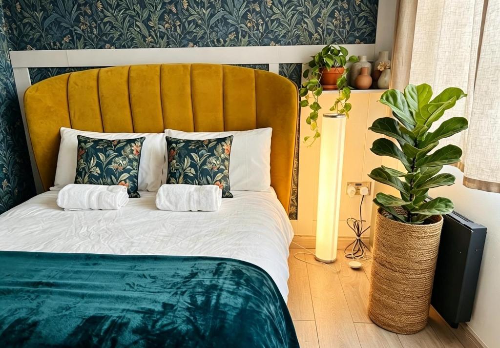 a bedroom with a bed with a yellow headboard at CROKE PARK STUDIO in Dublin