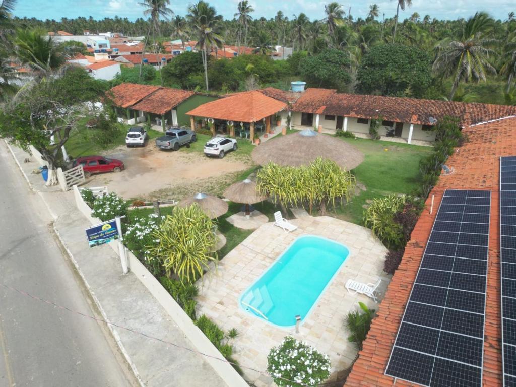 an aerial view of a house with a swimming pool and solar panels at Pousada Parque dos Coqueiros in Piaçabuçu