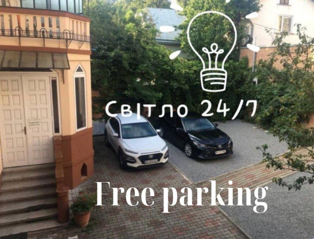 two cars parked in a parking lot with a light bulb at Номер та Паркінг in Chernivtsi