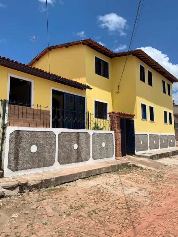a yellow house with a fence in front of it at Pousada da Cida in Lençóis