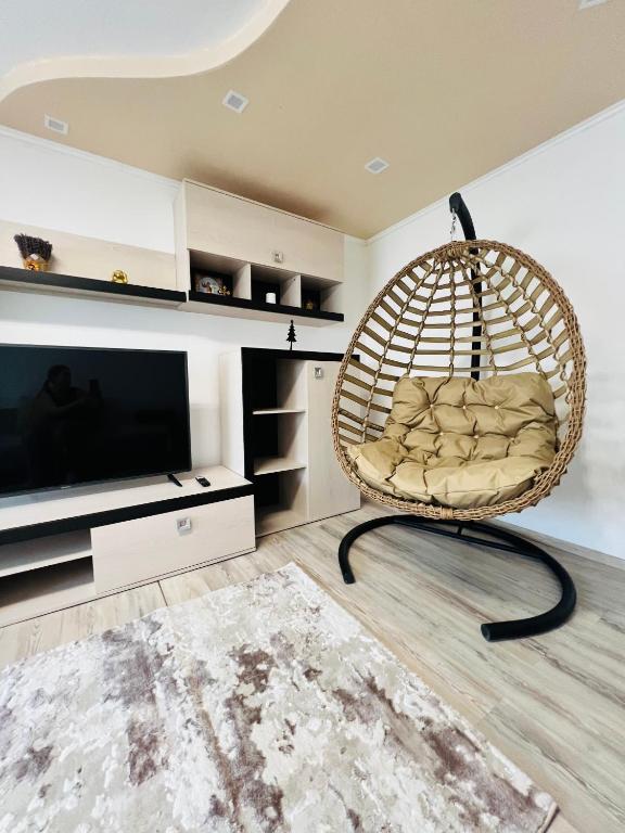 a room with a rattan chair in front of a television at Imperium DK Apartament in Giurgiu