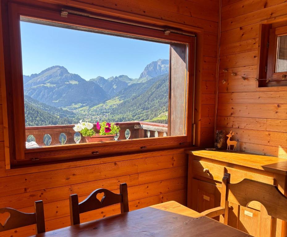 a dining room with a window with a view of mountains at Central Hostel Chatel in Châtel